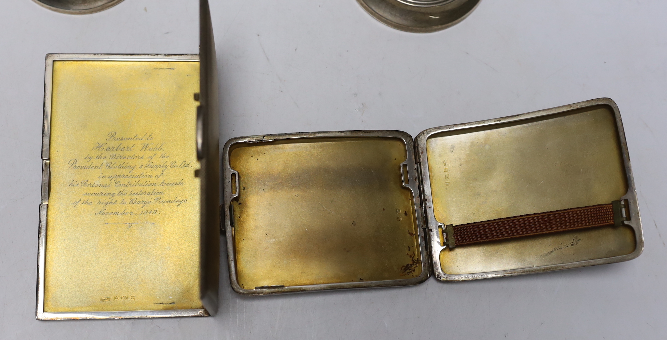 Two engine turned silver cigarette cases, largest 13.5cm and a pair of silver mounted dwarf candlesticks.